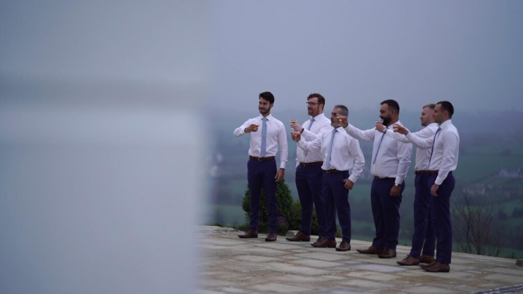 Cody and the groomsmen toast a glass of whiskey