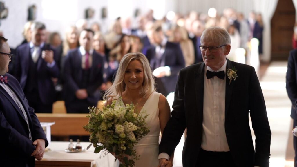 Proud Dad Tony walks daughter Anne Marie up the aisle in still frame from Ballintubber Abbey Wedding Video