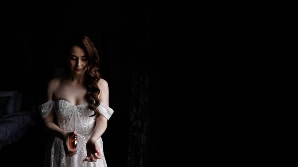 A still image from the wedding video at Rockhill House of bride Clodagh putting on her perfume